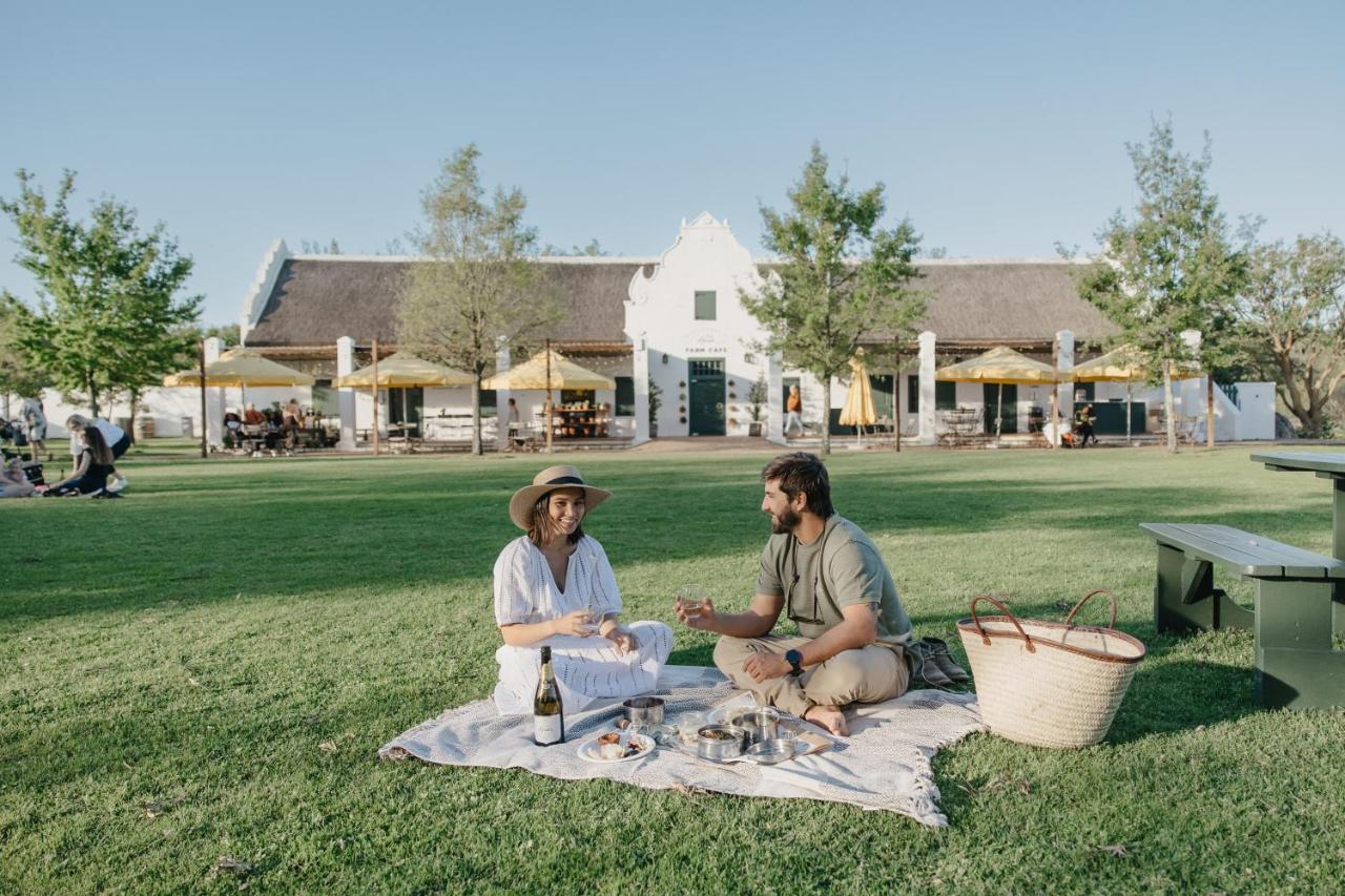 Couple having a picnic on a lawn in Spier Wine Farm