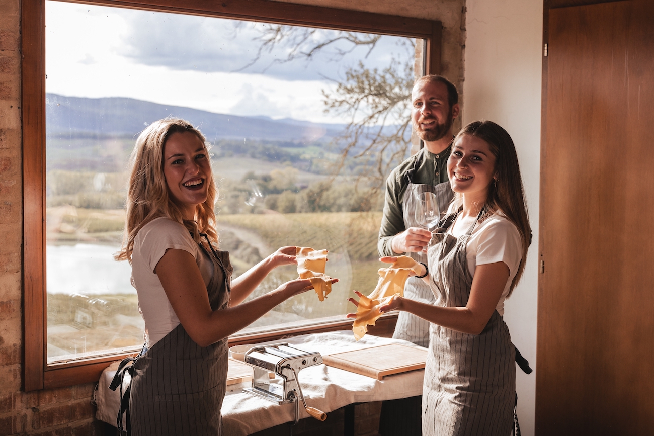 Image of a three people enjoying making pasta as a part of Forzoni Tours cooking class and wine pairing tours 